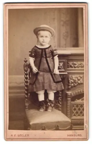 Fotografie H. F. Seeler, Hamburg, Stein-Strasse 26, Kind auf gepolstertem Stuhl