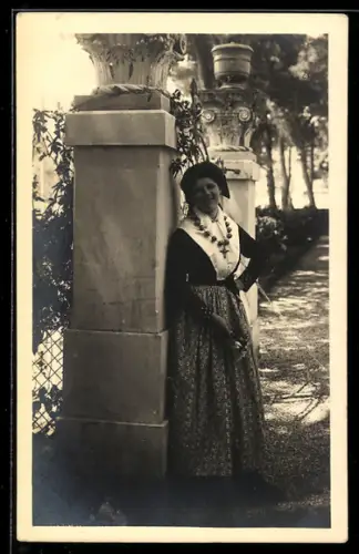 AK Dubrovnik, Junge Frau in Tracht vor einem steinernen Portal