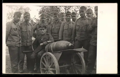 Foto-AK Soldaten in Uniform mit einem Artilleriegeschoss