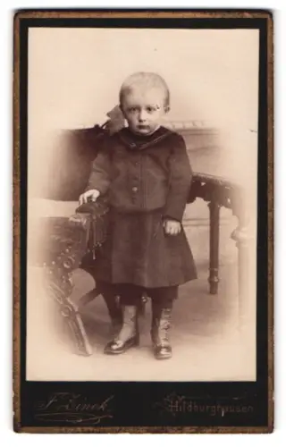 Fotografie F. Zinkch, Hildburghausen, Stehendes Kind in dunkler Kleidung