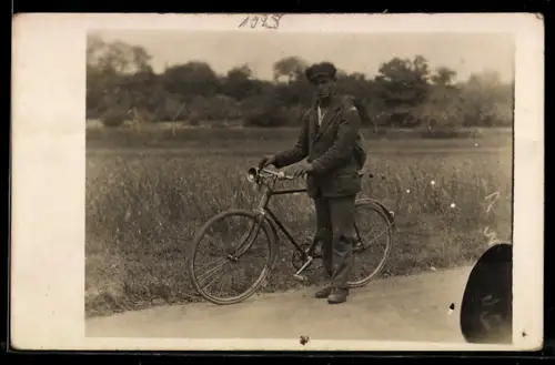 Foto-AK Junger Mann mit Fahrrad vor einem Feld