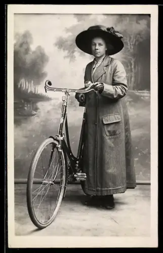 Foto-AK Frau mit grossem Hut mit ihrem Fahrrad, Atelieraufnahme
