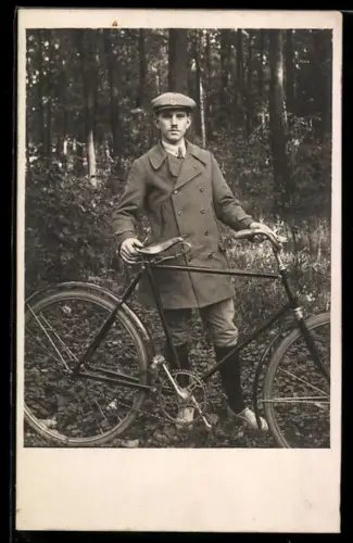 Foto-AK Mann mit Fahrrad in einem Waldgebiet