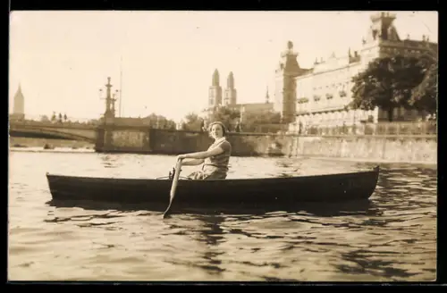 Foto-AK Frau in einem Ruderboot, Im Hintergrund Kirche