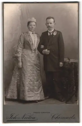 Fotografie Joh. Nicolou, Chemnitz, König-Strasse 3 & 5, Braut in gemustertem Kleid mit ihrem Bräutigam im Atelier