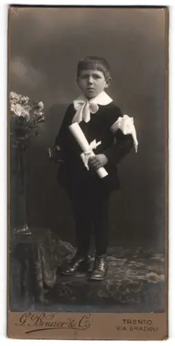 Fotografie G. Bruner & Co., Trento, Via Grazioli, Porträt eines Jungen mit Blumen zur Kommunion