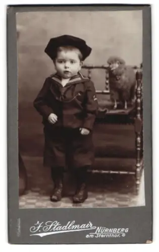 Fotografie F. Stadlmair, Nürnberg, am Sternthor, Kind in Matrosenanzug mit Spielzegschaf auf Stuhl