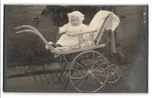 Fotografie unbekannter Fotograf und Ort, Kleinkind in einem Kinderwagen