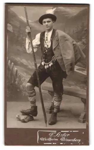 Fotografie F. Hofer, Weilheim, Junger Mann in deutscher Tracht mit Wanderstab