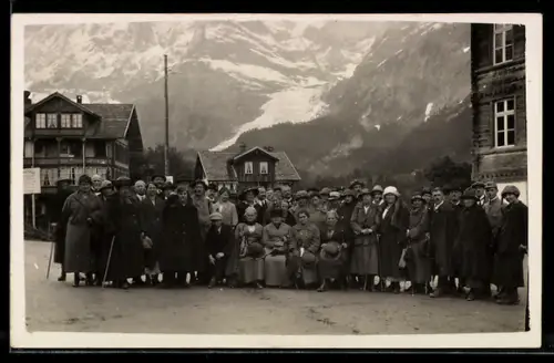 Foto-AK Grindelwald, Abzug von Grindelwald, Touristengruppe auf einem Platz im Ort