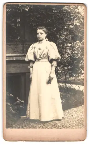 Fotografie unbekannter Fotograf und Ort, Frau im Garten stehend