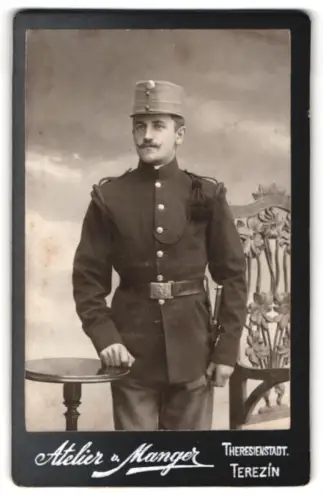 Fotografie Atelier v. Manger, Theresienstadt, Porträt eines Soldaten in Uniform im Atelier