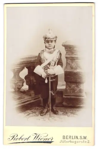 Fotografie Robert Wiener, Berlin, Jüterbogerstr. 2, Kind in Kürassier-Uniform mit Kürass, Pickelhaube und Pallasch