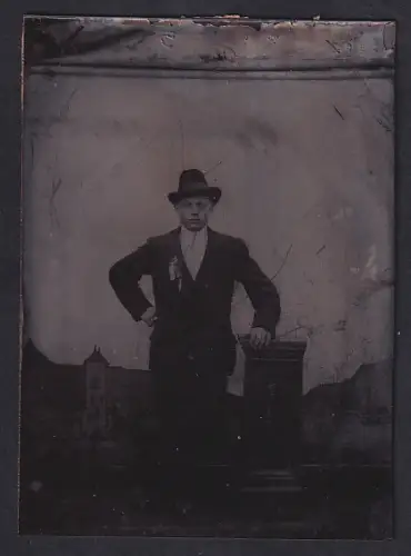 Fotografie Ferrotypie unbekannter Fotograf und Ort, Mann in Anzug mit Hut im Atelier
