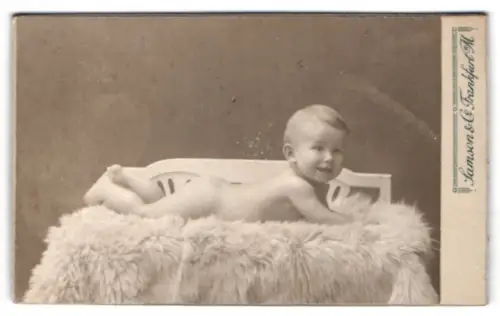 Fotografie Samson & Co., Frankfurt am Main, Kaiserstrasse 1, Lächelndes Baby auf Fellunterlage