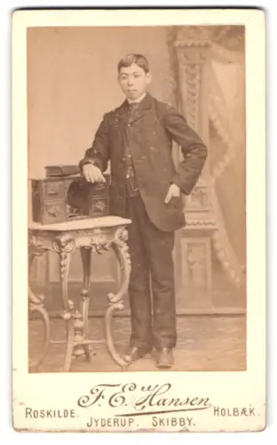 Fotografie F. E. Hansen, Roskilde, Junge im Anzug mit Tisch