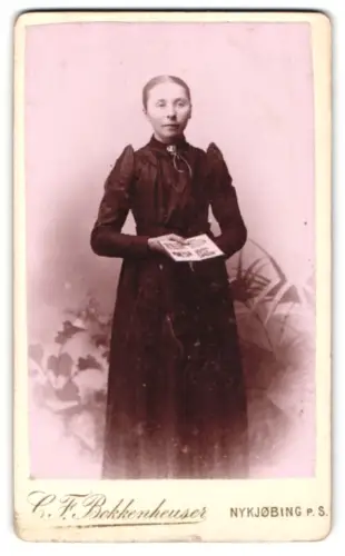 Fotografie C.F. Bokkenheuser, Nykjøbing, Dame mit Fotografien in der Hand