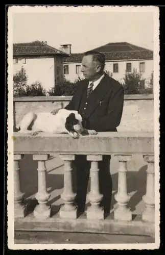 Foto-AK Auf einer Balustrade liegender Hund mit seinem Herrchen