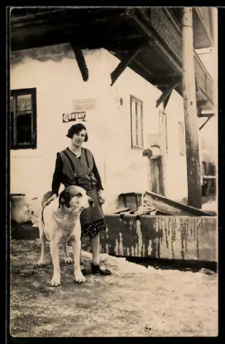 Foto-AK Frau in Kittelschürze mit Hund vor einem Geschäftshaus