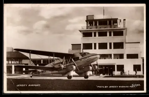 Künstler-AK Flughafen Jersey, Doppeldecker-Flugzeug der Jersey Airways Ltd. vor dem Flughafengebäude