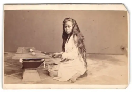 Fotografie unbekannter Fotograf und Ort, Malaysia Mädchen mit langem Haar spielt Xylophon
