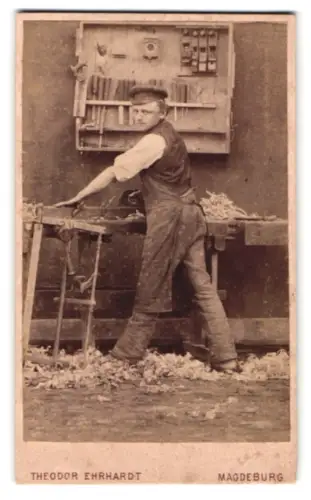 Fotografie Theodor Ehrhardt, Magdeburg, Jacobstrasse 14b, Schreiner mit Holzhobel an der Werkbank stehend