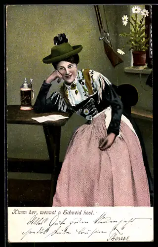 AK Frau in Tracht mit Hut an einem Tisch sitzend