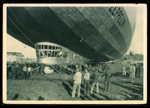 AK Zeppelin mit Haltemannschaft an Haltetauen und Stroppen