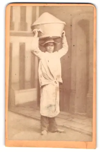 Fotografie unbekannter Fotograf und Ort, Südamerikanischer Junge trägt einen grossen Topf, Butter