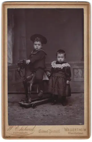 Fotografie W. Ehrhard, Wallertheim, Zwei Kinder mit Spielzeugpferd auf Rollen
