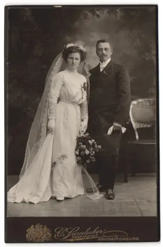 Fotografie C. Samhaber, Aschaffenburg, Elegantes Brautpaar mit Blumenstrauss