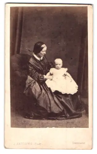 Fotografie J. Andrews, Swansea, Ältere Dame mit Kleinkind auf Sessel