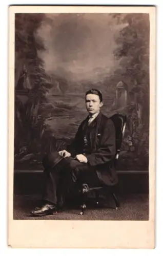 Fotografie E. Thomas, Chippenham, The Causeway, Portrait eines sitzenden Mannes vor malerischem Hintergrund