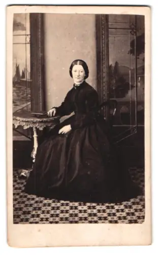 Fotografie D. Abrahams, Bath, Cleveland Place 12, Dame in dunklem Kleid am Tisch