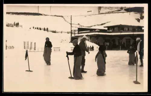 Foto-AK Menschen beim Wintersport in einem verschneiten Ort