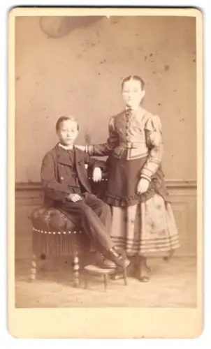 Fotografie Georg Aulmann, Offenbach a. M., Hospitalstrasse 16, Zwei Geschwister in feiner Kleidung zusammen im Atelier