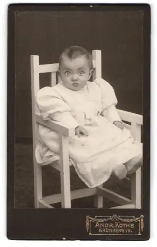 Fotografie Andr. Kothe, Grünberg i. H., Kind im weissen Kleid auf einem Stuhl