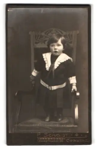 Fotografie F. Schmidt, Coblenz, Lohrstrasse 96, Kind in elegantem Kleid auf Stuhl