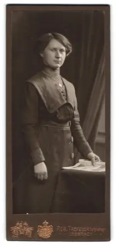 Fotografie Rob. Trefzger, Lörrach, Stehende Frau mit Tisch