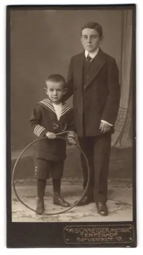 Fotografie Alphons Schneider, Berlin-Tempelhof, Borussiastrasse 19, Zwei Jungen in Matrosenanzug und Anzug mit Reifen