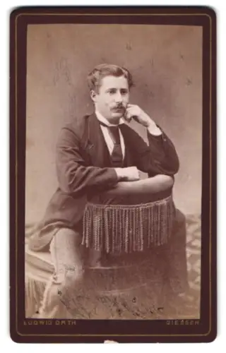 Fotografie Ludwig Orth, Giessen, Nachdenklicher Herr lehnt sich an einen Stuhl