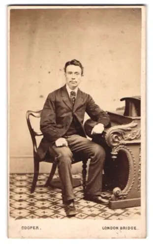 Fotografie M. Felton Cooper, London, Eleganter Herr am Tisch