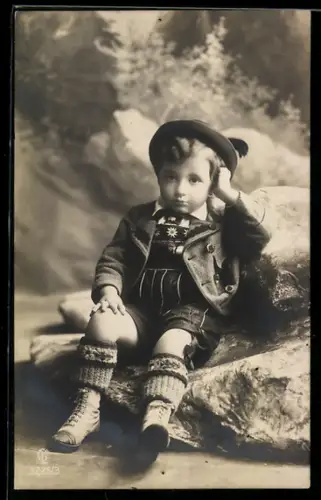 Foto-AK GL Co Nr. 3225/3: Kleiner Junge in Tracht sitzt auf einem Felsen