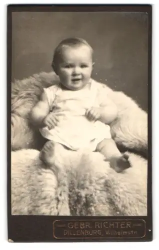 Fotografie Gebr. Richter, Dillenburg, Wilhelmstr., Kleinkind auf flauschiger Decke