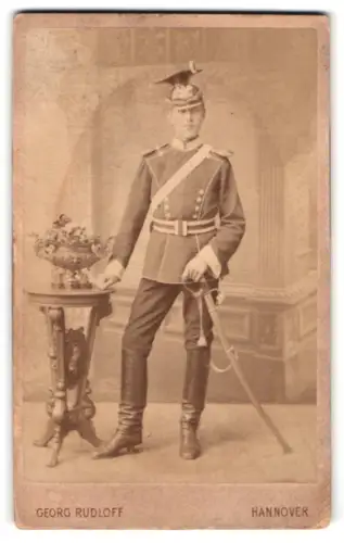 Fotografie Georg Rudloff, Hannover, Georg-Strasse 12, Ulan in Uniform mit Tschapka und Säbel