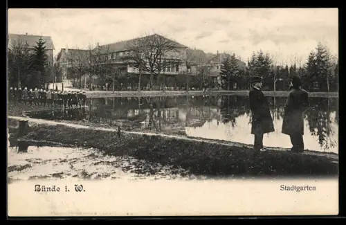 AK Bünde i. W., Stadtgartenpartie mit Teich, Knabengruppe, Herren in Mänteln, Gebäudepanorama