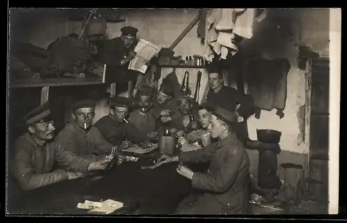 Foto-AK Wachfreie Soldaten in einem Unterstand beim Kartenspiel, 1 Soldat mit Glatzer Zeitung