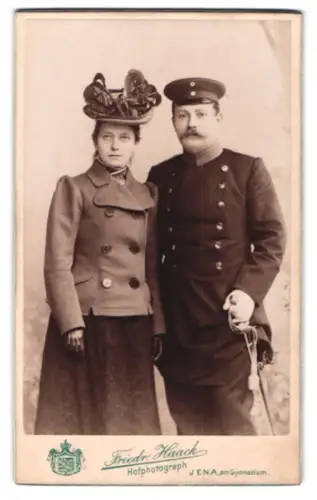 Fotografie Friedr. Haack, Jena, Am Gymnasium, Offizier im Überrock mit Schirmmütze und Säbel und seiner Frau