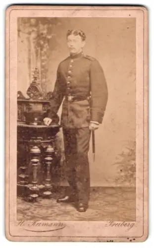 Fotografie H. Reimann, Freiberg, Weingasse 9, Soldat vom Regiment Nr. 12 in Uniform mit Schirmmütze und Bajonett