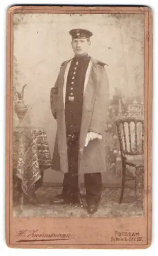 Fotografie H. Zwirnemann, Potsdam, Schock-Str. 27, Gefreiter in Uniform mit Mantel und Schirmmütze